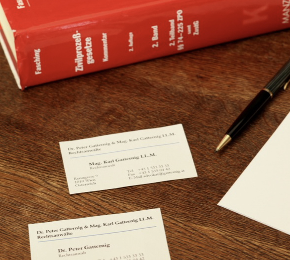 Ein Gesetzesbuch und Visitenkarten auf einem Tisch